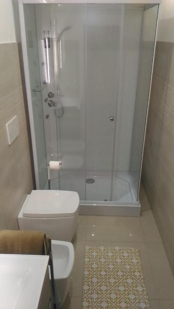 une salle de bain avec une douche, des toilettes et un lavabo dans l'établissement Villa delle Muse, à Fontane Bianche