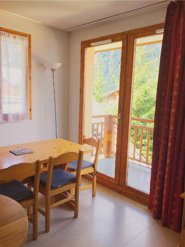 une salle à manger avec une table et un balcon dans l'établissement Appartement Ski Pied de Pistes - Valfréjus, à Modane