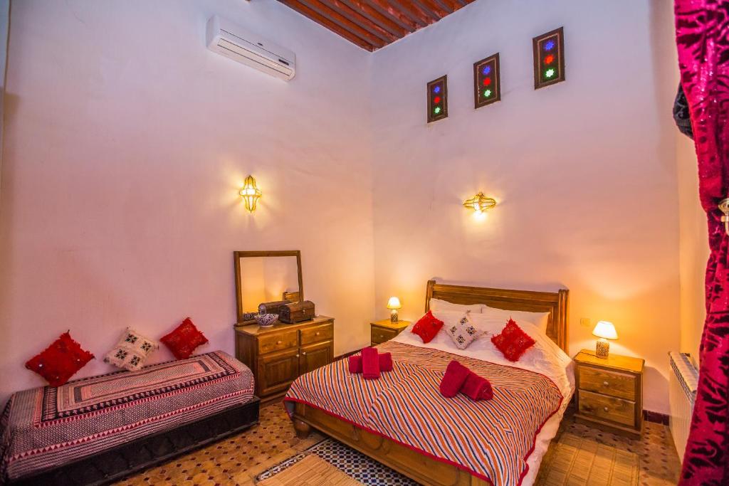 une chambre avec deux lits et un miroir dans l'établissement Riad Zina Fes - Elegance in the Heart of Fes, à Fès