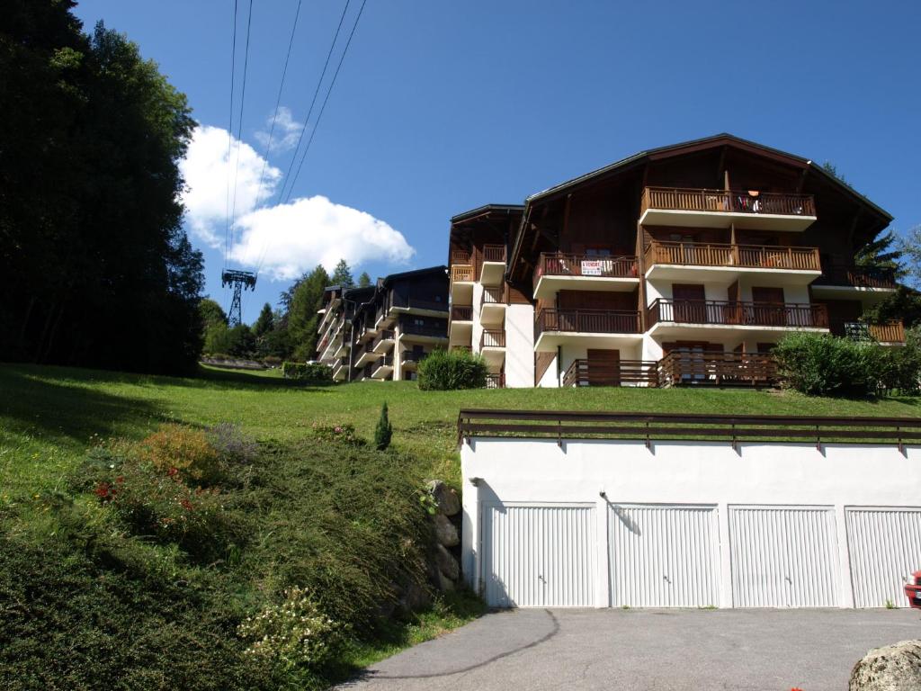 un immeuble d'appartements avec un garage blanc en face dans l'établissement Chalet La Piste Bleu, à Saint-Gervais-les-Bains
