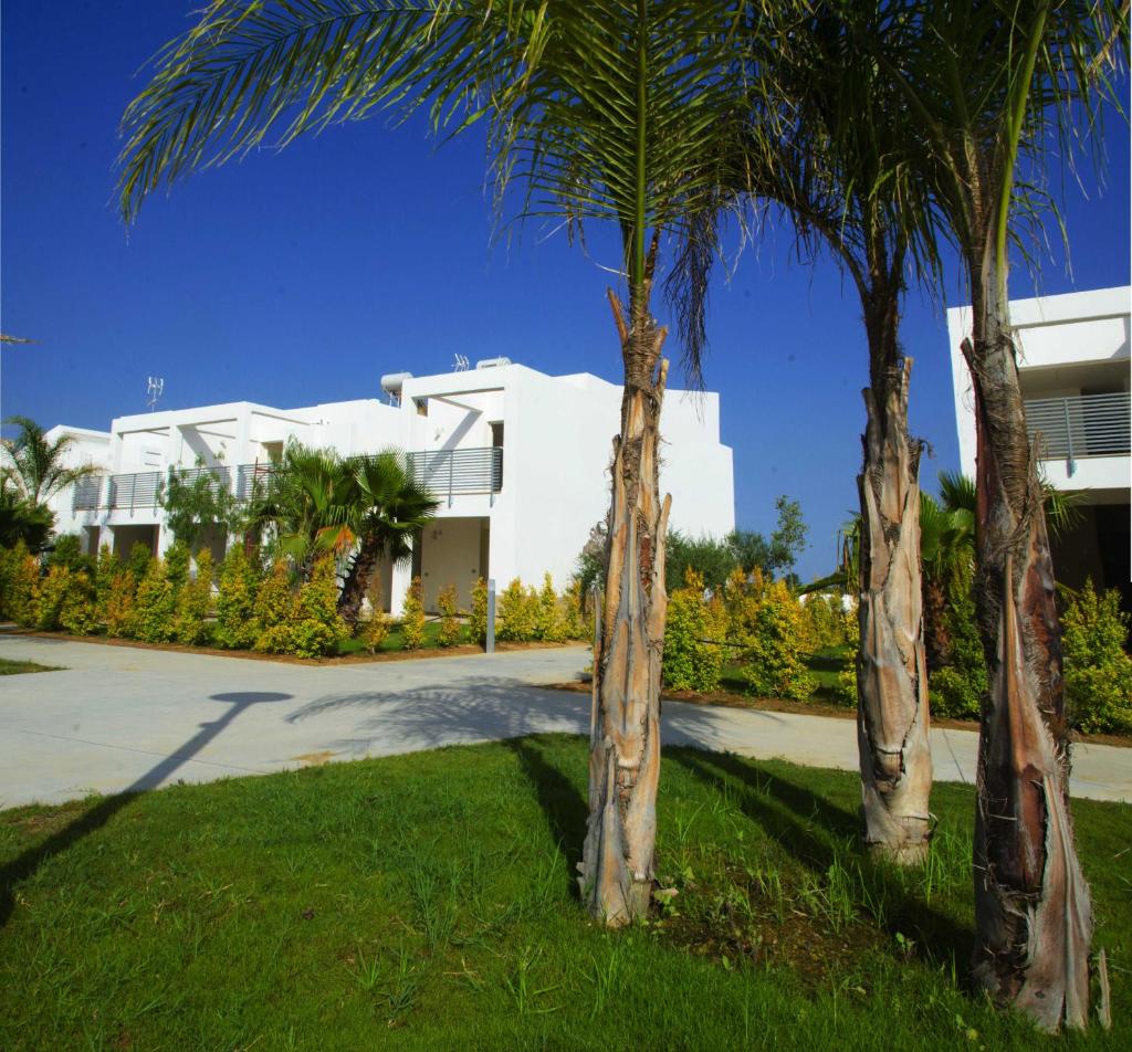 deux palmiers devant un bâtiment blanc dans l'établissement I GIARDINI DI ZEUS, à Métaponte