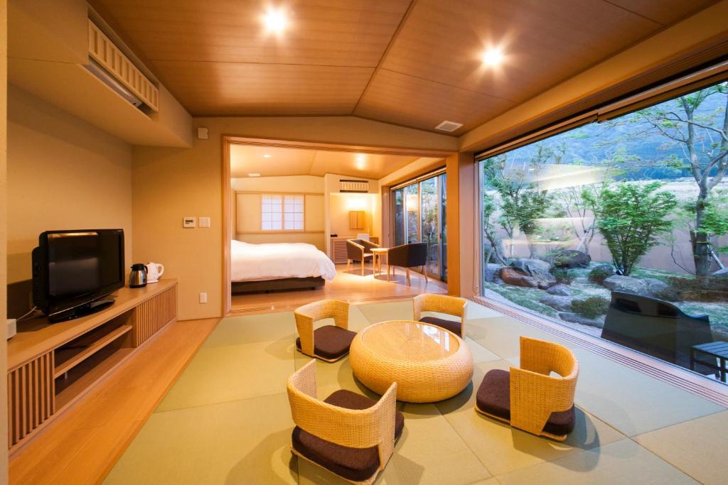 Cette chambre comprend un lit et une grande fenêtre. dans l'établissement Okuyado Buaiso, à Yufu