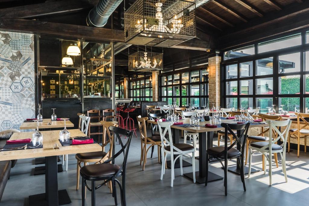 une salle à manger avec tables, chaises et fenêtres dans l'établissement Hotel Villa Tirreno, à Tarquinia