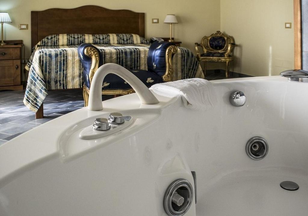 - une baignoire dans une chambre avec un lit dans l'établissement Hotel Baia, à Palinuro