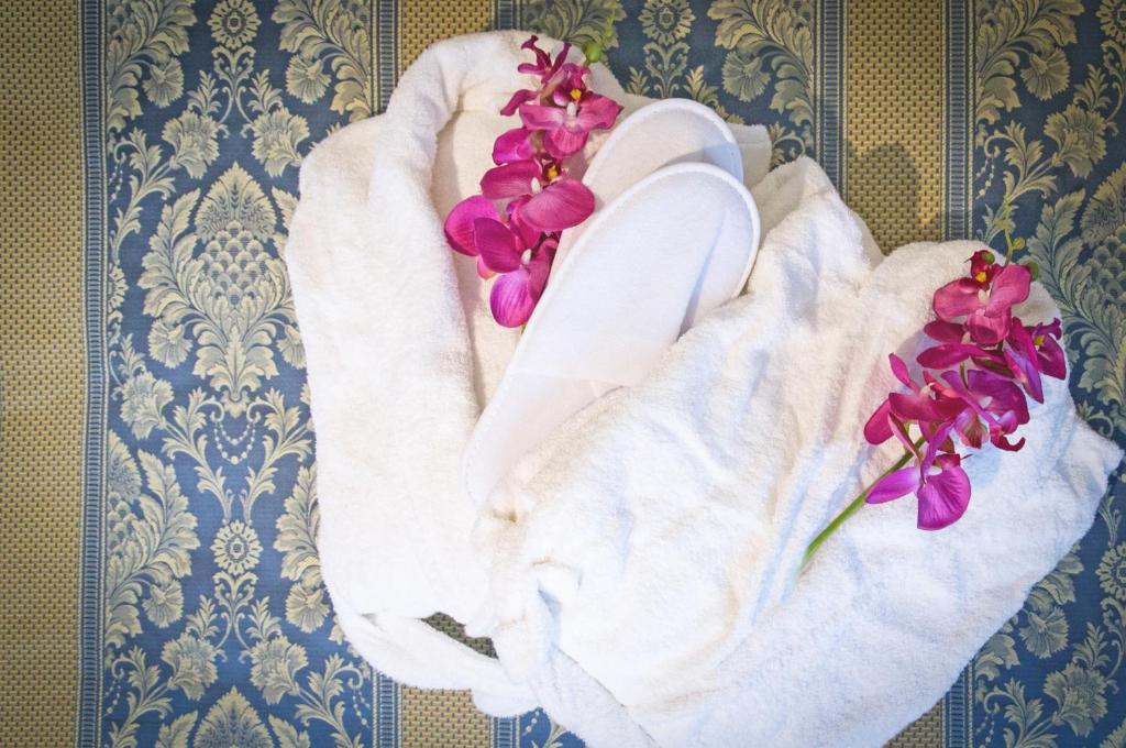 - une serviette avec des fleurs violettes sur une table dans l'établissement Hotel La Meridiana, sur le Lido de Venise 138 autres photos