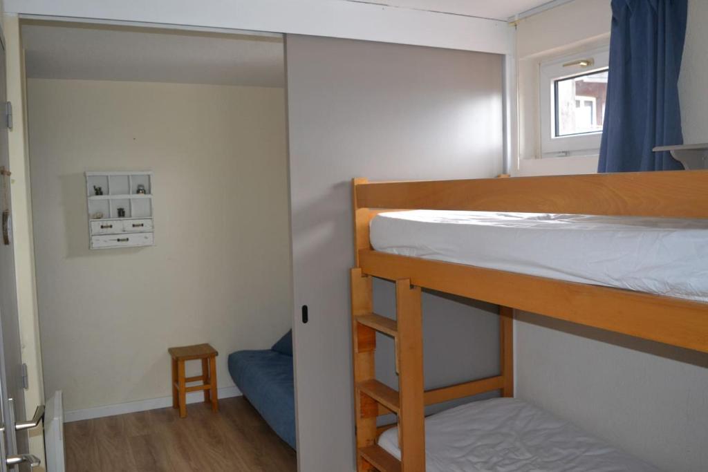 Ce lit superposé se trouve dans une petite chambre dotée d'un petit tabouret. dans l'établissement Appartement pied des pistes 4 à 6 pers - Les Deux-Alpes, à Les Deux Alpes