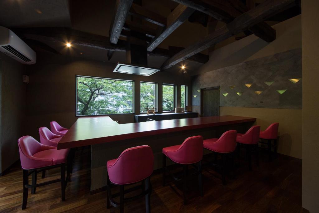 - un bar dans une pièce avec des chaises roses dans l'établissement Ryokan Yoshidaya, à Ureshino