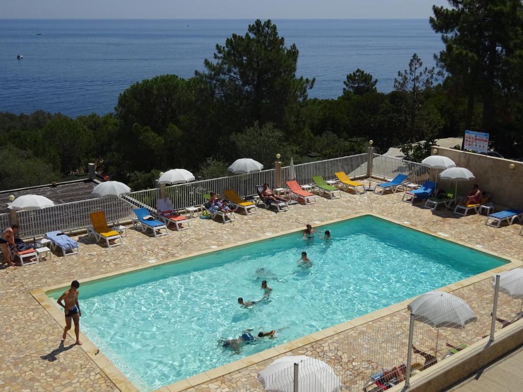 un groupe de personnes nageant dans une piscine dans l'établissement Camping Mozziconaccio, à Sainte-Lucie de Porto-Vecchio