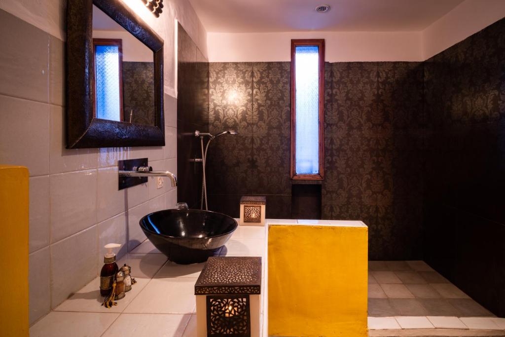 une salle de bain avec un lavabo et un miroir dans l'établissement Riad Azcona, à Marrakech 37 autres photos