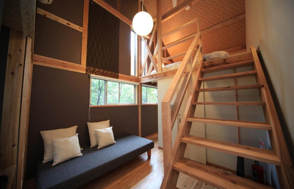 une chambre avec un lit superposé et un escalier dans l'établissement Oita Toranoyu, à Kokonoe