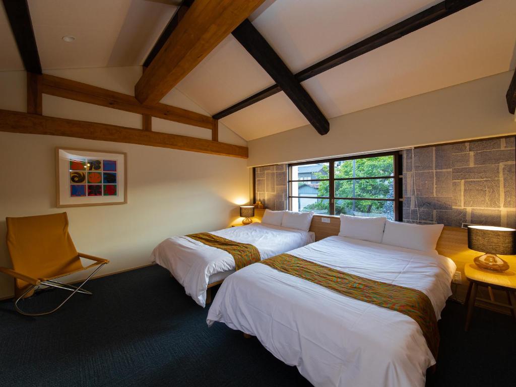 une chambre avec deux lits et une fenêtre dans l'établissement 内子の宿 久, à Uchiko