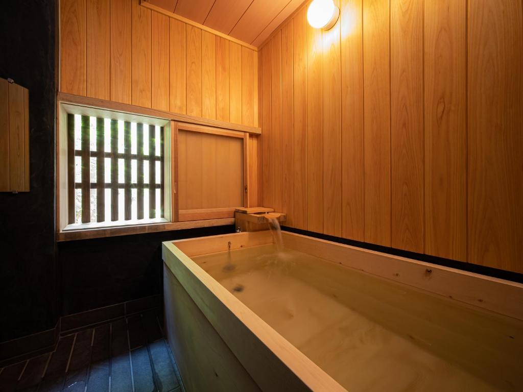 Cette chambre en bois dispose d'une baignoire et d'une fenêtre. dans l'établissement 内子の宿 久, à Uchiko 37 autres photos