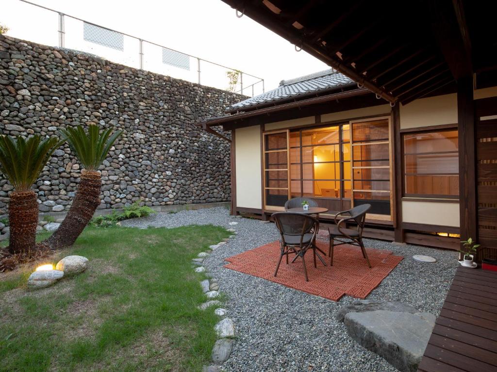 un patio avec une table et des chaises à côté d'un bâtiment dans l'établissement 内子の宿 久, à Uchiko