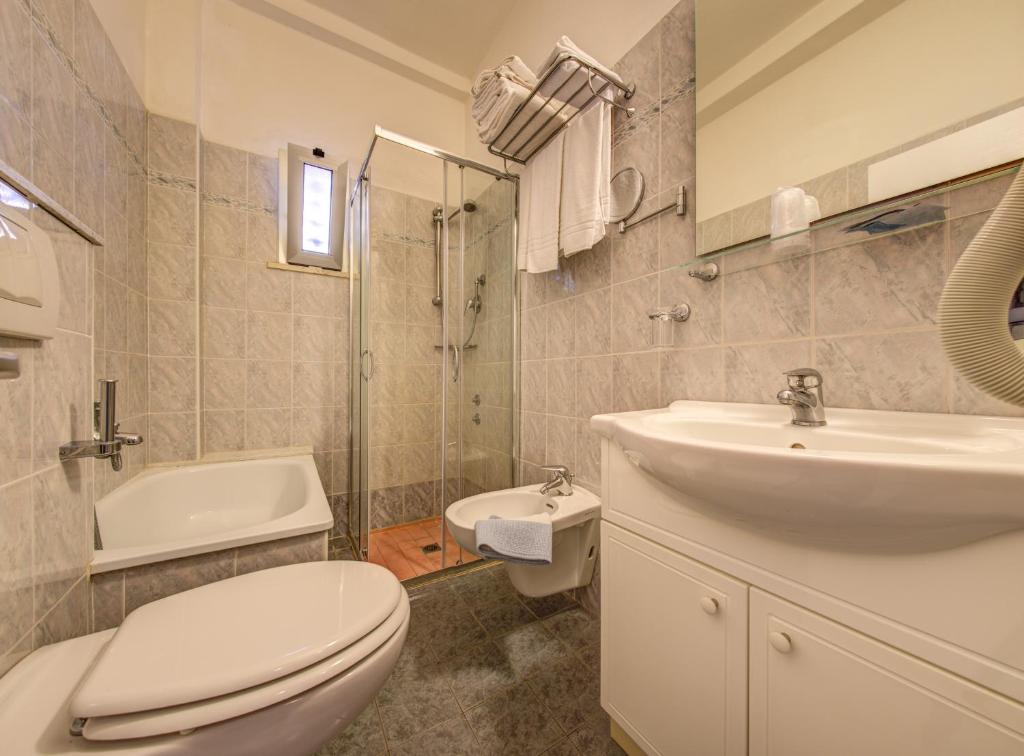 une salle de bain avec toilettes et lavabo dans l'établissement Hotel San Giorgio, à Milano Marittima