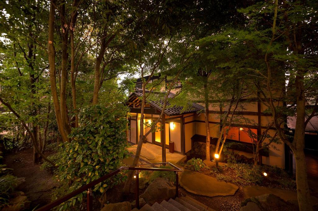 une maison au milieu d'une forêt la nuit dans l'établissement Yufuin Onsen Toshoan, à Yufu