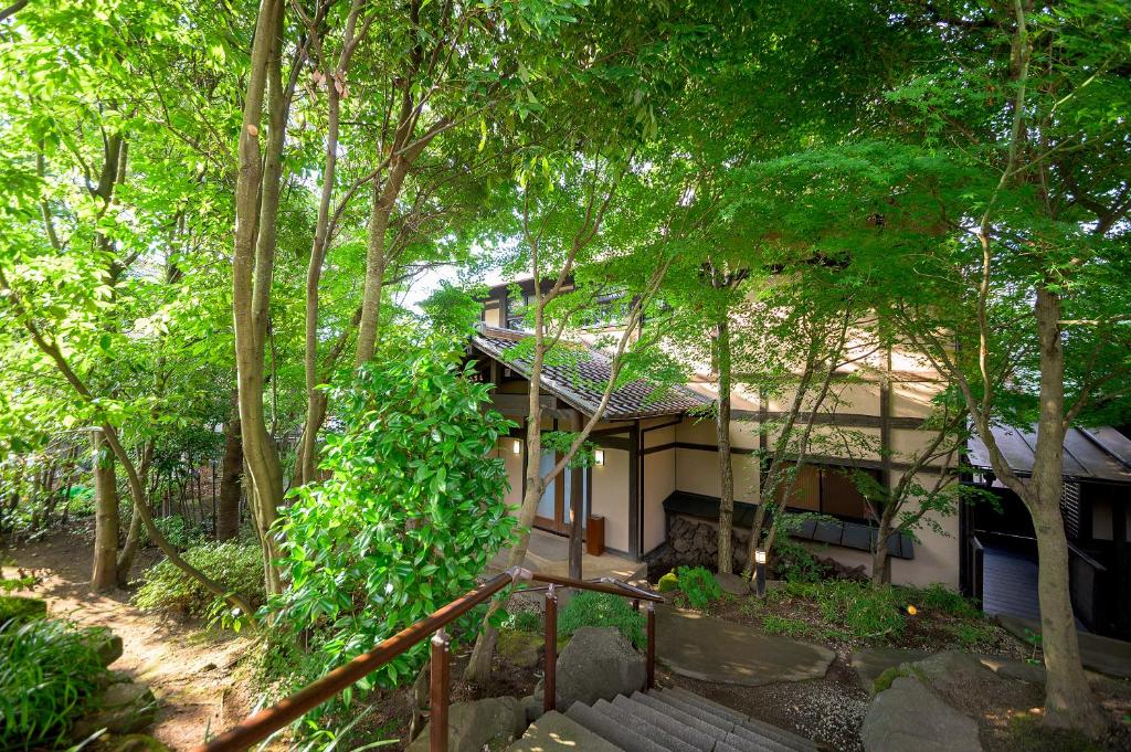une maison au milieu des arbres dans l'établissement Yufuin Onsen Toshoan, à Yufu
