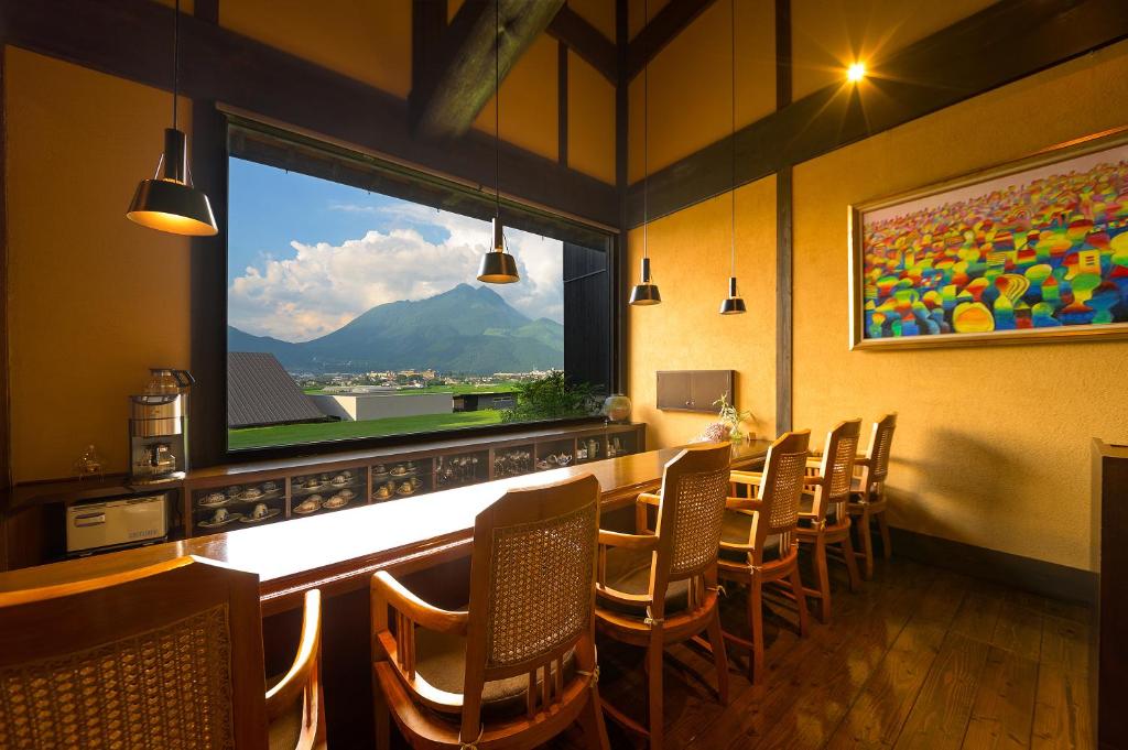 un restaurant avec un bar avec des chaises et une grande fenêtre dans l'établissement Yufuin Onsen Toshoan, à Yufu