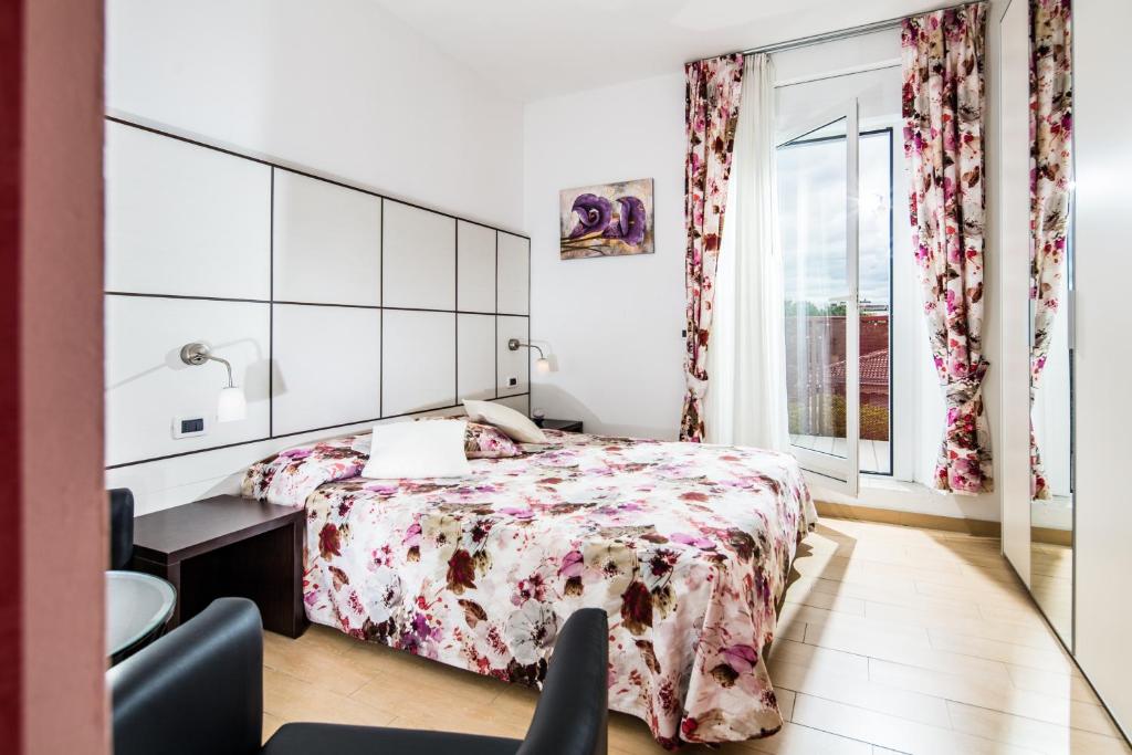 une chambre avec un lit, un bureau et une fenêtre dans l'établissement Hotel Vienna, à Lignano Sabbiadoro 120 autres photos