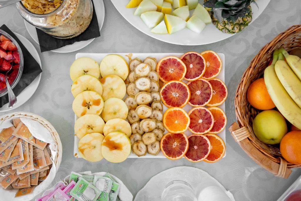 une table recouverte de assiettes de fruits et de légumes dans l'établissement Hotel T Depandance, à Rimini