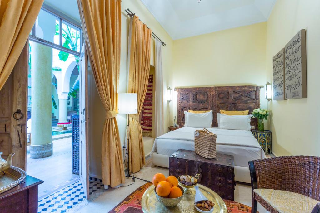 - une chambre avec un lit et une table avec des oranges dans l'établissement Riad Azoulay, à Marrakech