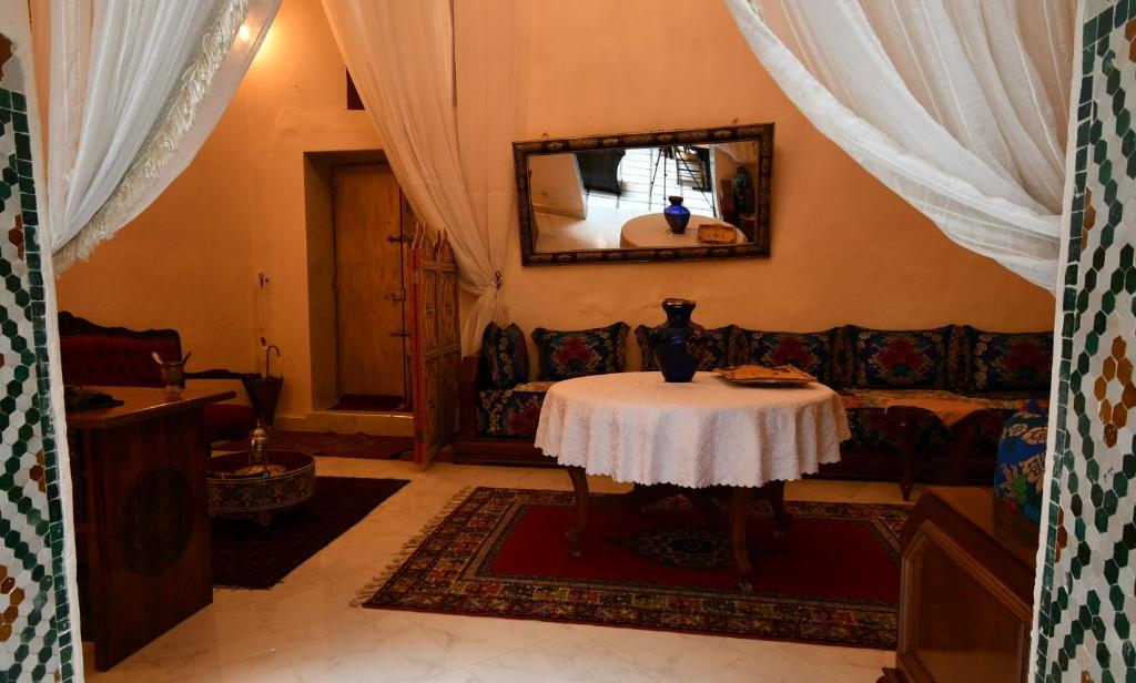 un salon avec une table et un canapé dans l'établissement Riad AlKATIB Meknès, à Meknès