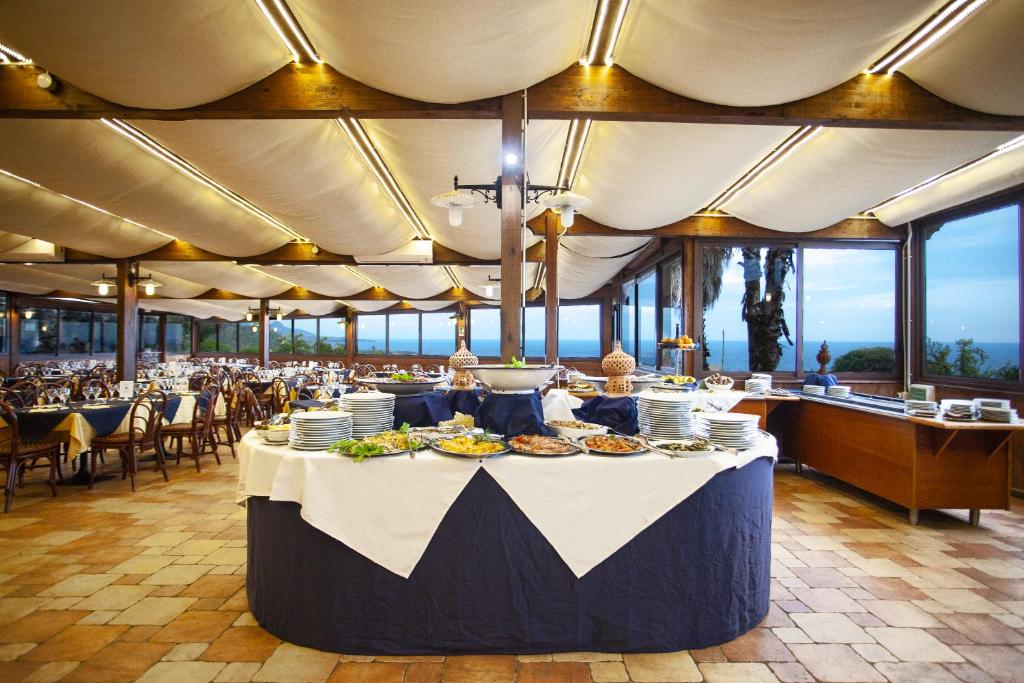 un restaurant avec une table avec de la nourriture dessus dans l'établissement Pantelleria Resort, à Pantelleria