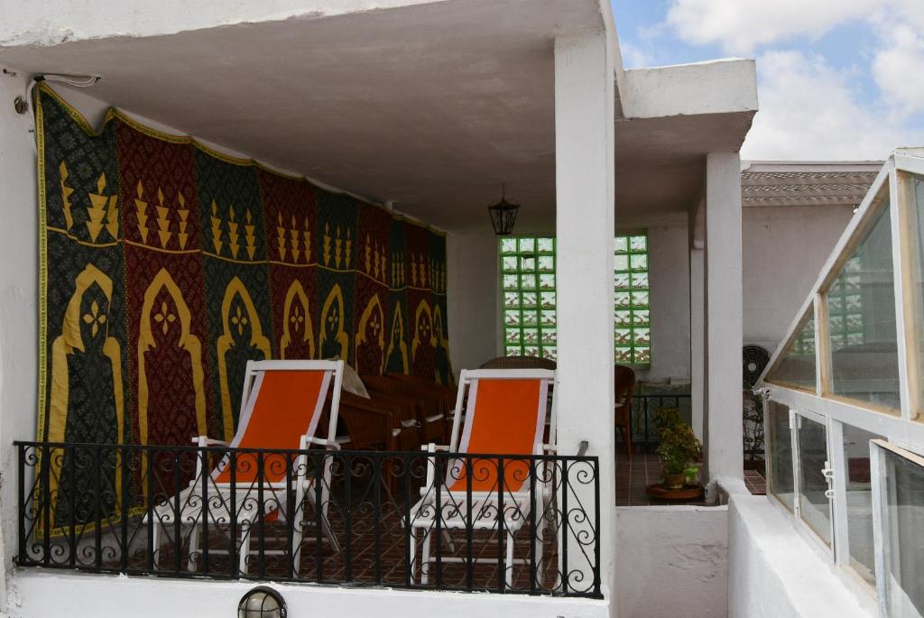 - deux chaises sur un balcon avec tapisserie dans l'établissement Riad AlKATIB Meknès, à Meknès