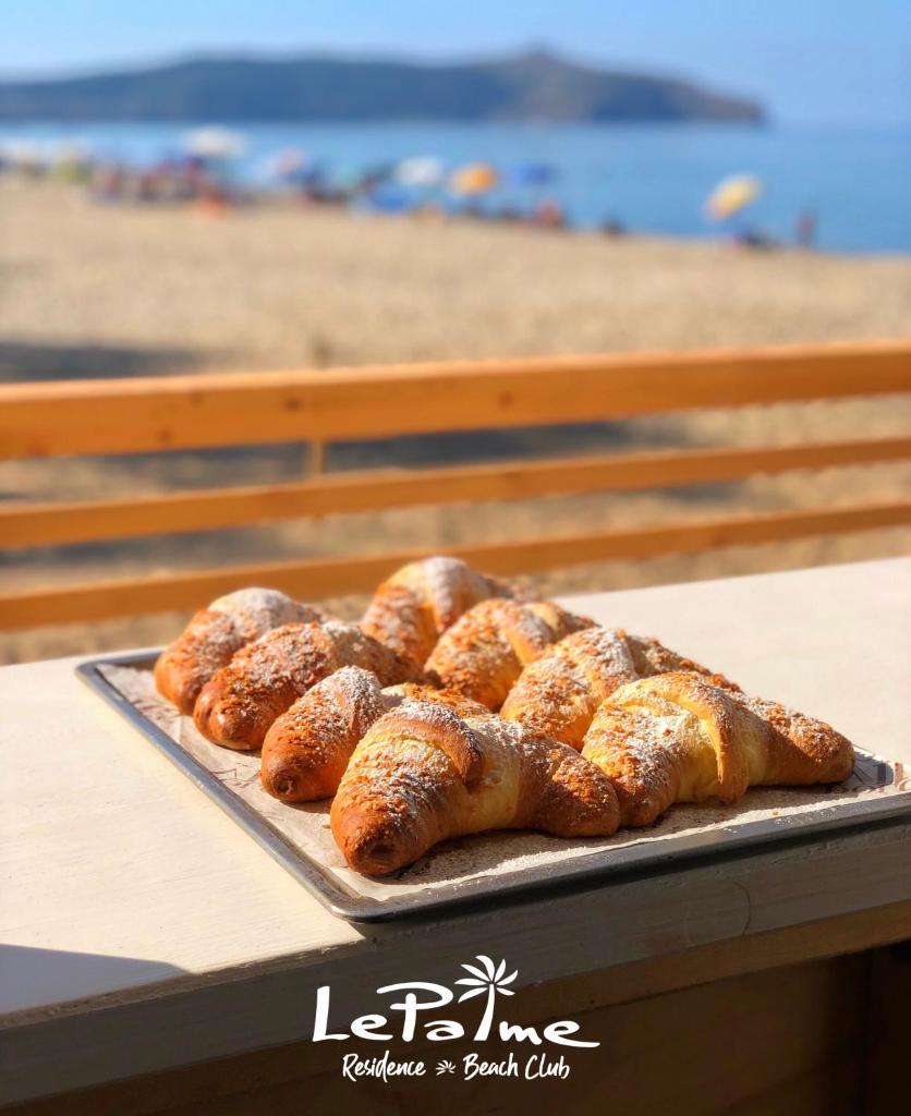 - un plateau de pain sur une table à côté de la plage dans l'établissement Residence Le Palme - Appartamenti sul mare - Spiaggia tra Palinuro e Caprioli, à Pisciotta