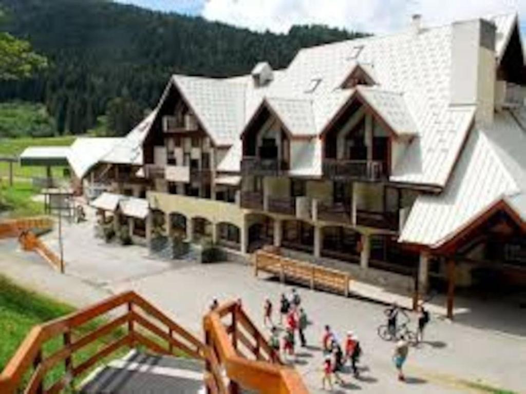 un groupe de personnes debout à l'extérieur d'un grand bâtiment dans l'établissement Poutran 2, studio 4 personnes au pied des pistes avec grande terrasse, à Oz