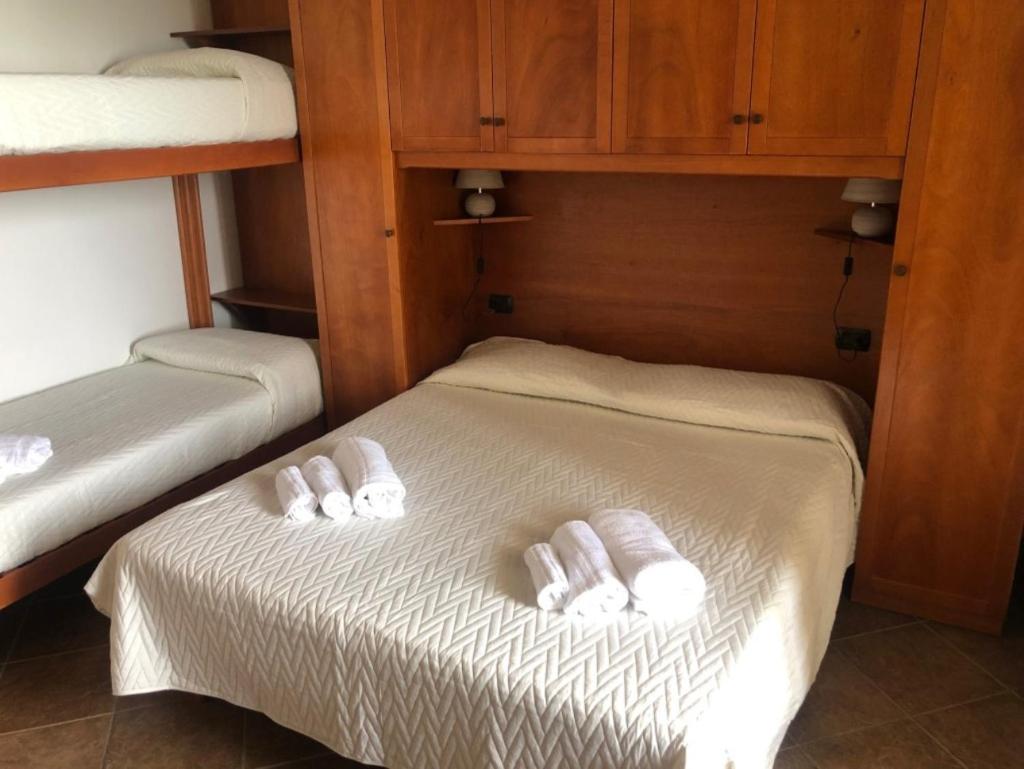 - 2 lits dans une chambre avec des serviettes blanches dans l'établissement Residence Le Palme - Appartamenti sul mare - Spiaggia tra Palinuro e Caprioli, à Pisciotta