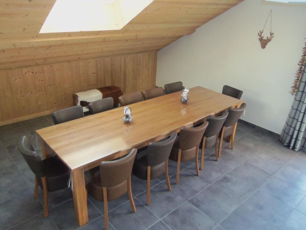 une salle de conférence avec une table et des chaises en bois dans l'établissement Chalet Beausoleil 4 étoiles - jacuzzi - au pied du Col de la Croix de Fer, à Saint-Sorlin-dʼArves