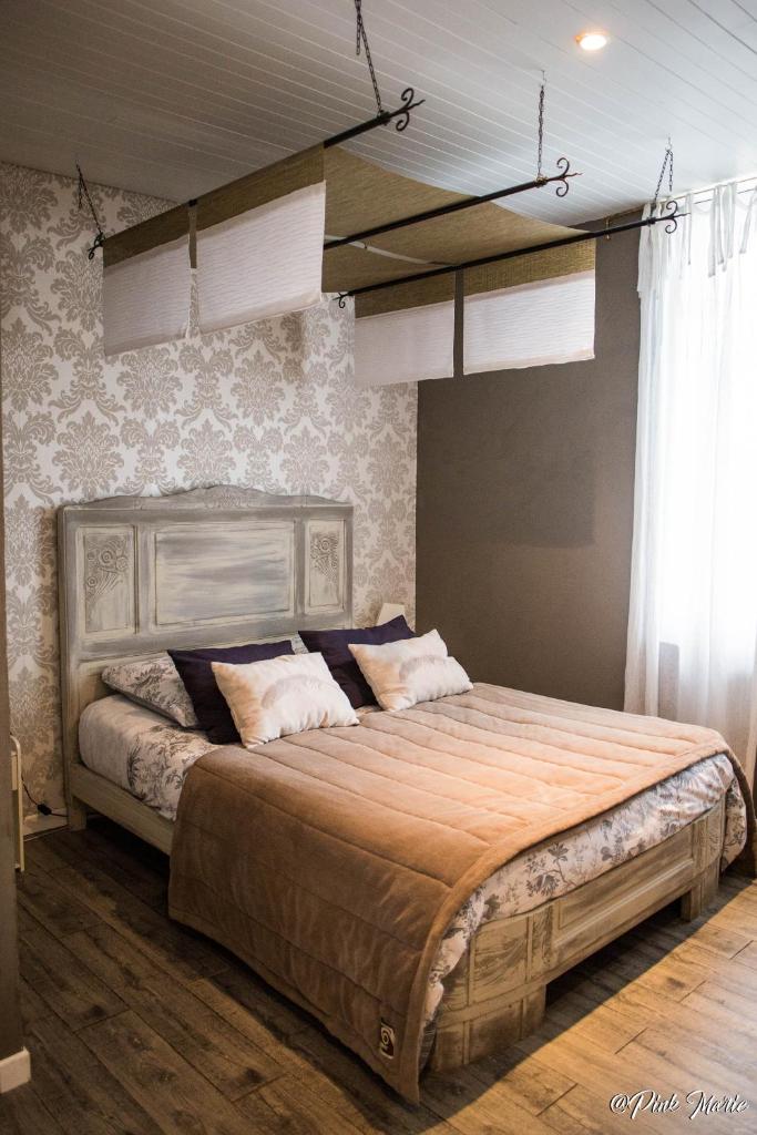 une chambre avec un grand lit dans une pièce dans l'établissement Chambres d'hôtes Le Pessac, à Vielmur