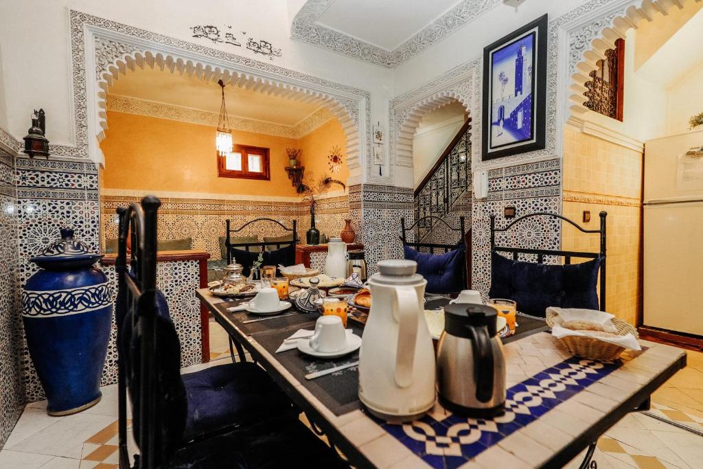 - une salle à manger avec une table et des vases dans l'établissement Riad For S, à Marrakech