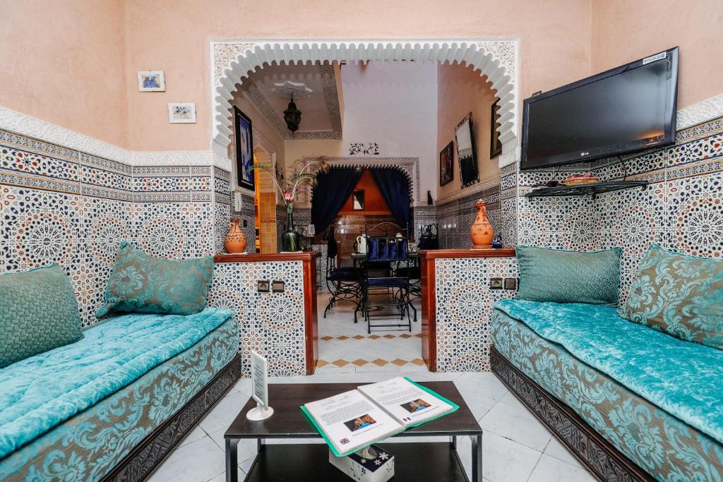un salon avec deux canapés et une télévision dans l'établissement Riad For S, à Marrakech