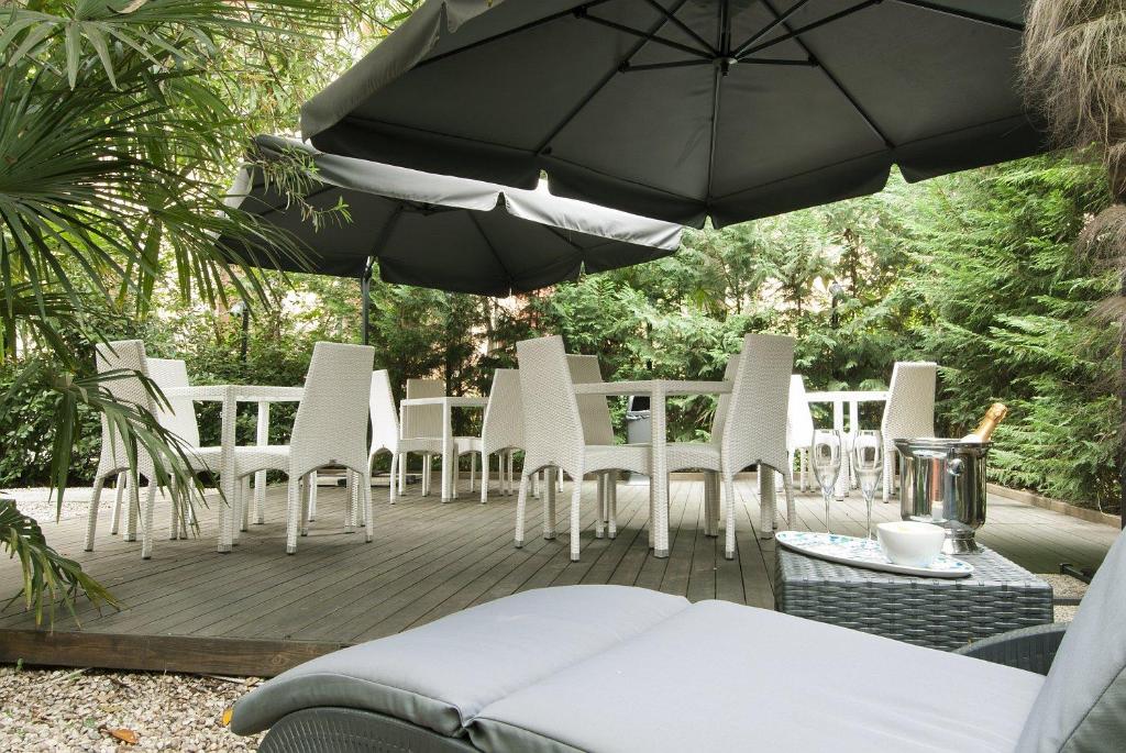 un tas de chaises et un parasol sur une terrasse dans l'établissement Hotel Villa Pannonia, sur le Lido de Venise