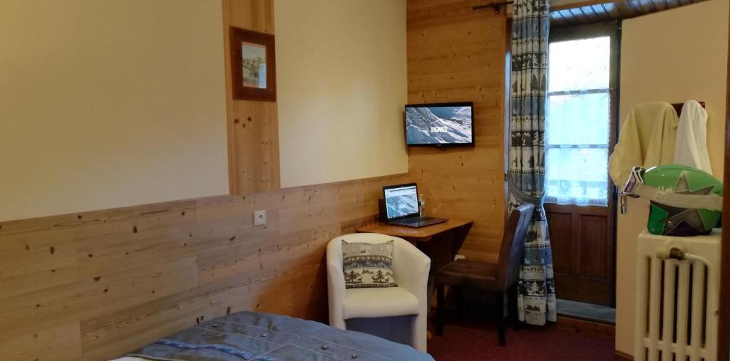une chambre avec un lit et un bureau avec un ordinateur dans l'établissement Le Dôme, à Tignes