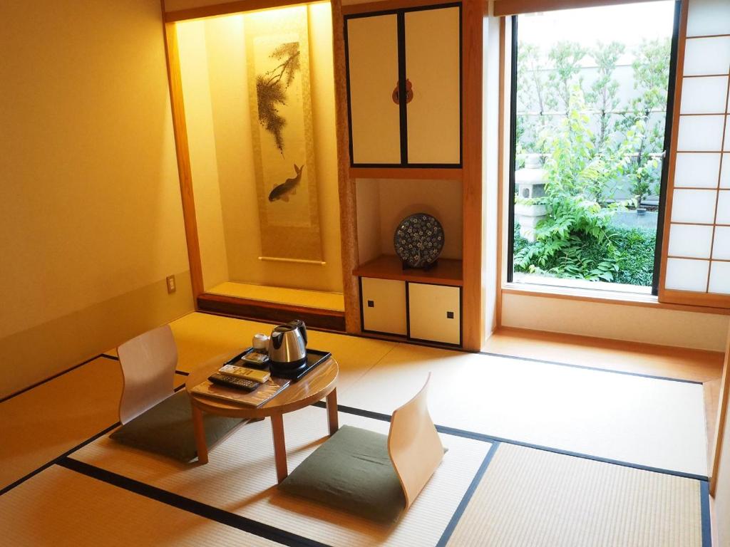 une pièce avec une table, des chaises et une fenêtre dans l'établissement The Edo Sakura, à Tokyo