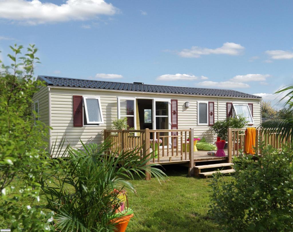 une petite maison avec un porche et une terrasse dans l'établissement Camping Officiel Siblu Le Bois Dormant, à Saint-Jean-de-Monts