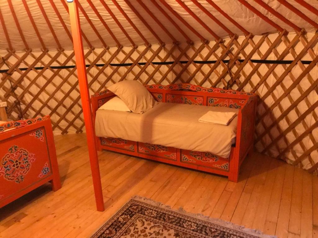une chambre avec un lit dans une yourte dans l'établissement yourte Coeur de Combray, à Ernes