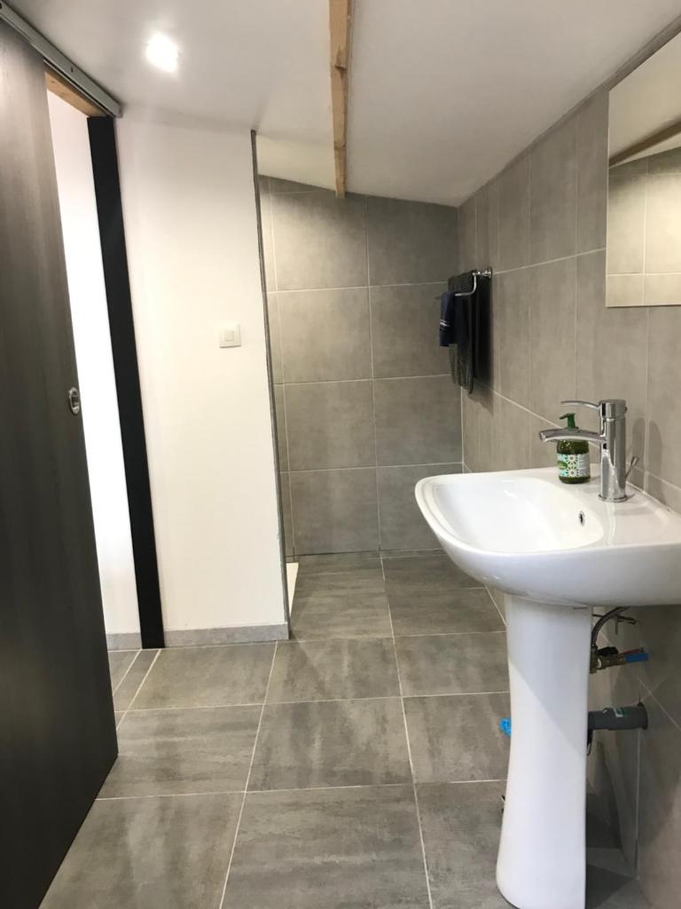une salle de bain avec un lavabo et une douche dans l'établissement yourte Coeur de Combray, à Ernes