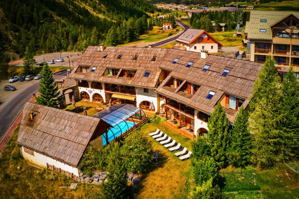 - une vue aérienne sur une grande maison dans les montagnes dans l'établissement Hôtel & Spa La Ferme de l'Izoard, à Arvieux