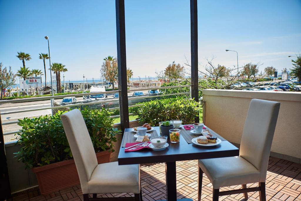 - une table avec de la nourriture sur un balcon avec vue sur le port dans l'établissement Alisei Palace Hotel, à Rimini