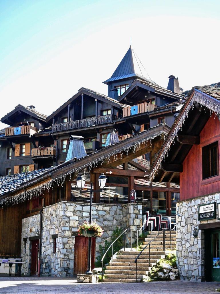 Un grand bâtiment avec des escaliers se trouve juste devant. dans l'établissement Arc 1950 Manoir Savoie Skis aux pieds, à Bourg-Saint-Maurice