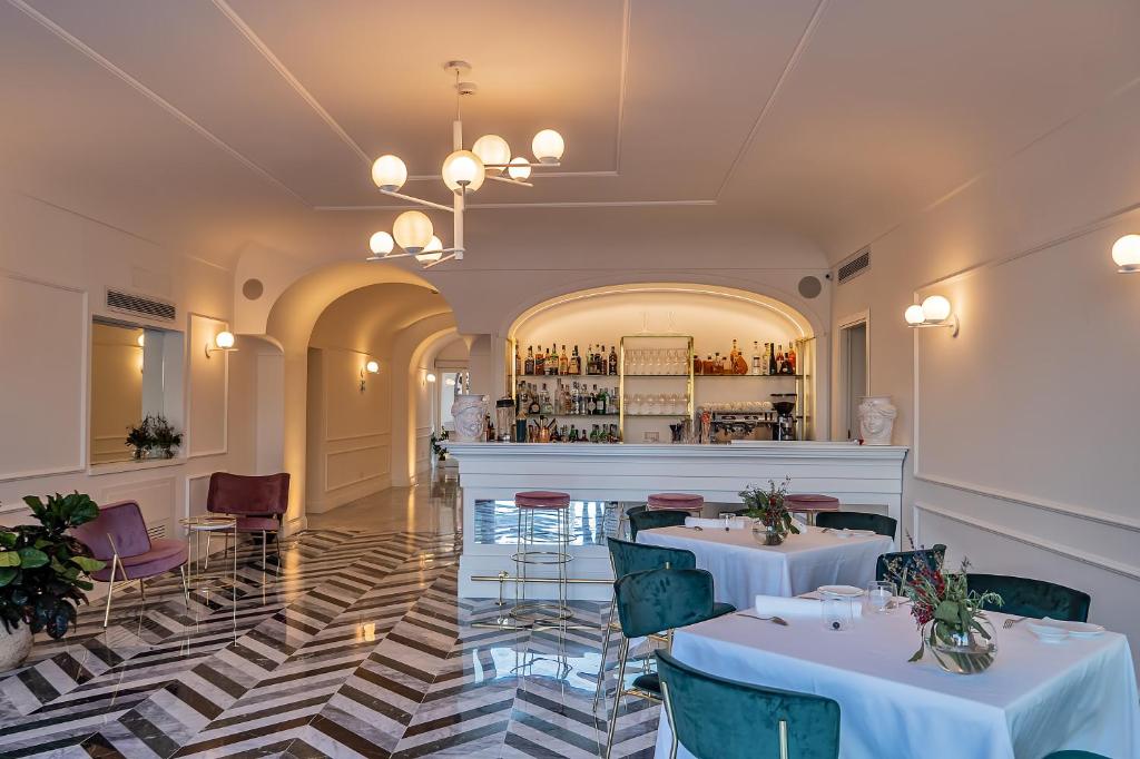 un restaurant avec deux tables et un bar dans l'établissement Hotel Lorelei Londres, à Sorrente