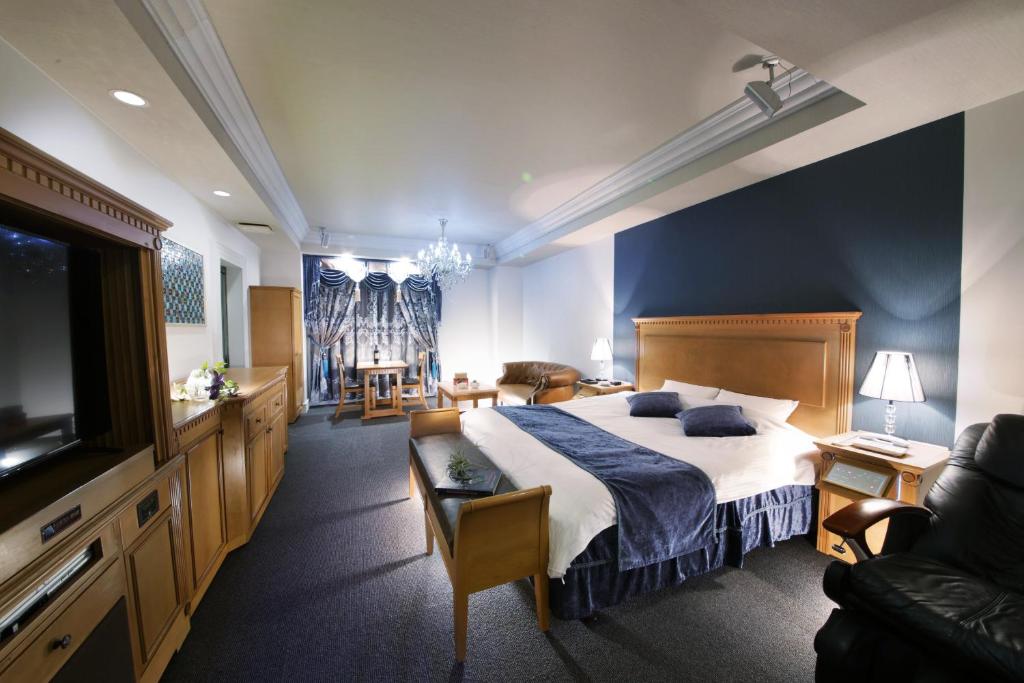 une chambre avec un grand lit et un salon dans l'établissement Nonno Classic Hotel (Adult Only), à Yokkaichi