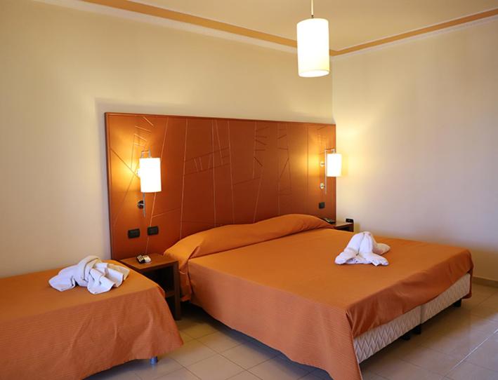 deux lits dans une chambre d'hôtel avec des serviettes dessus dans l'établissement Laghi Room Only, à Sibari