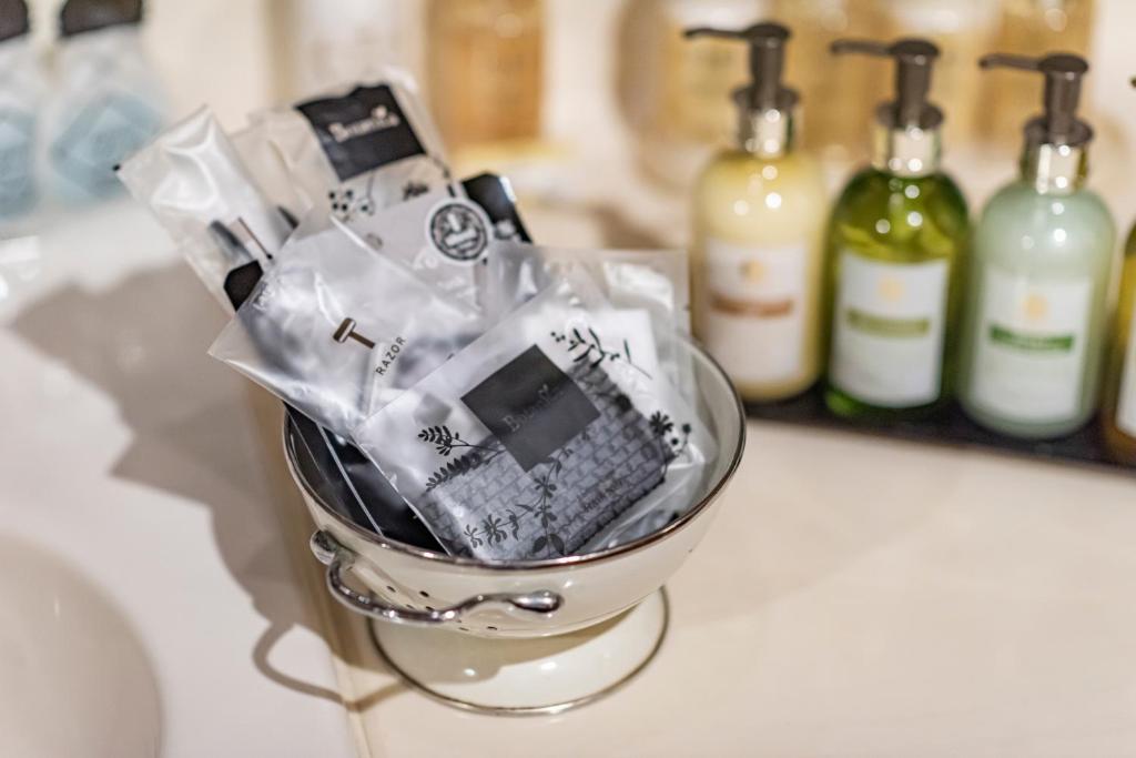 un récipient métallique rempli d'objets sur un comptoir avec des bouteilles de vin dans l'établissement Hotel Chapel Story Sakaihigashi (Adult Only), à Sakai