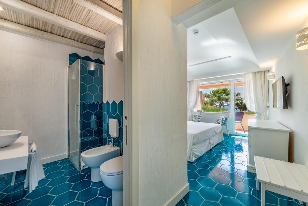 une salle de bain avec deux toilettes et un lavabo dans l'établissement Hotel Cala Lunga, à La Maddalena