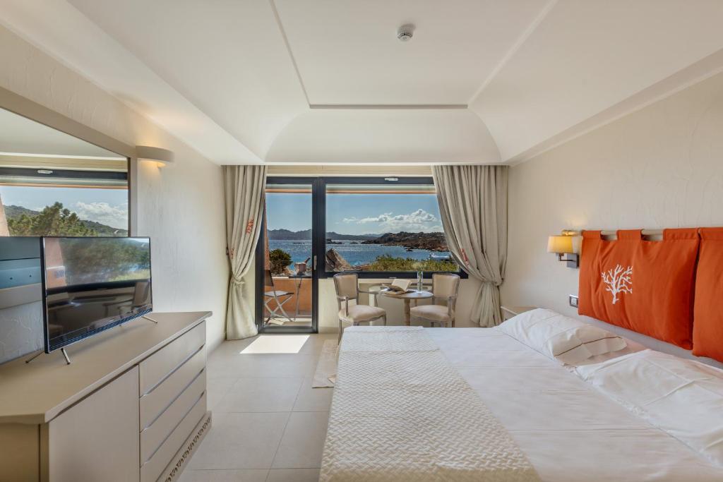 une chambre d'hôtel avec un grand lit et une télévision dans l'établissement Hotel Cala Lunga, à La Maddalena 289 autres photos