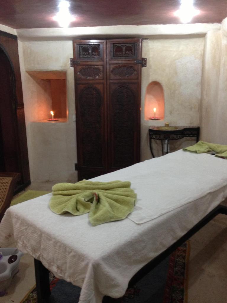 une chambre avec un lit avec une serviette verte dessus dans l'établissement Riad Ben Youssef, à Marrakech